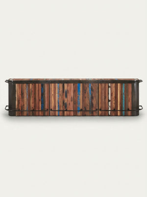 The Urban Wood Bar is a low, rectangular reclaimed wood cabinet with multicolored vertical slats in brown, blue, and teal, plus black metal handles on each side. Shown against a plain white background.