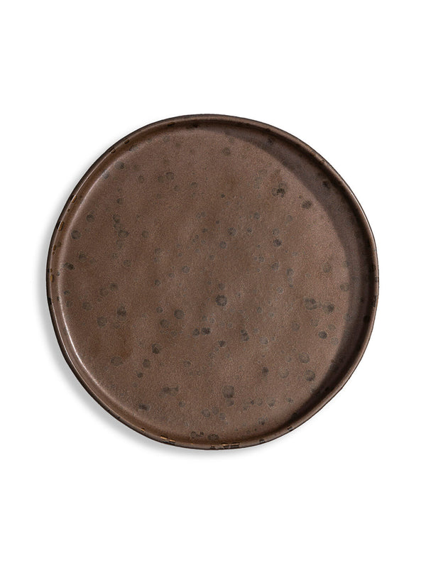 The Juniper Plate Range features four round, dark brown plates with a speckled finish and organic, irregular edges—beautifully handcrafted for stacking or display, ideal for adding unique character to any table setting.