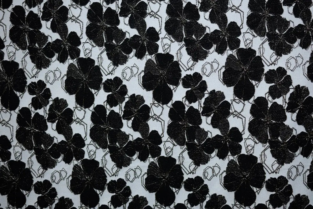 Table linen with dramatic black florals on a neutral backdrop create bold sophistication for statement event tables.