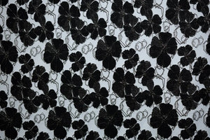Table linen with dramatic black florals on a neutral backdrop create bold sophistication for statement event tables.