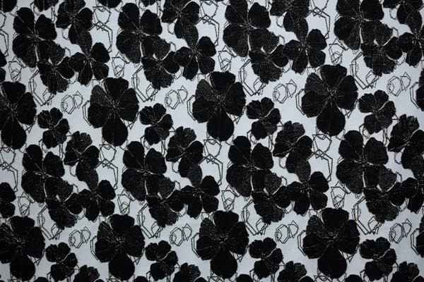 Table linen with dramatic black florals on a neutral backdrop create bold sophistication for statement event tables.