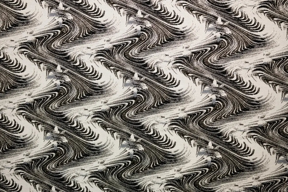 Table linen with swirling abstract motifs with shimmering gold thread add dynamic elegance to luxurious tablescapes.