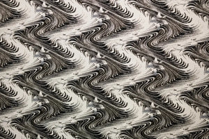 Table linen with swirling abstract motifs with shimmering gold thread add dynamic elegance to luxurious tablescapes.