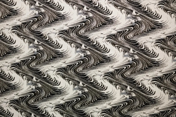 Table linen with swirling abstract motifs with shimmering gold thread add dynamic elegance to luxurious tablescapes.
