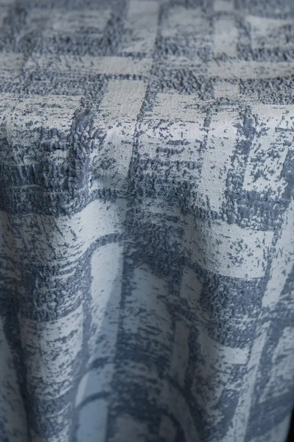 Table linen with textured geometric elegance in soft tones, bringing modern sophistication to refined table settings.