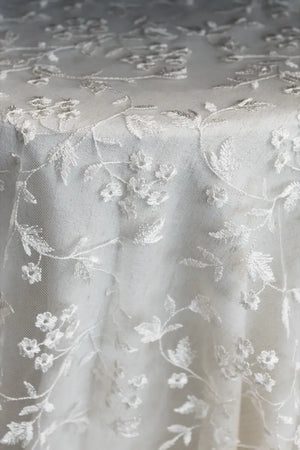Table linen with lace overlay adding intricate texture and vintage charm to elegant, timeless tables.