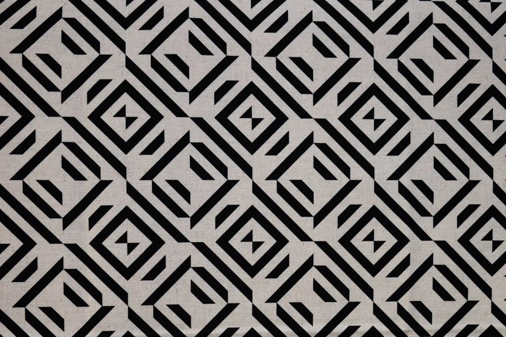 Table linen with dynamic black geometric patterns on neutral fabric add modern edge and bold style to tables.