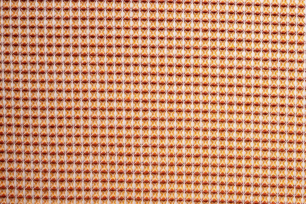 Table linen with rich texture meets warm elegance with bold waffle pattern in burnt orange.