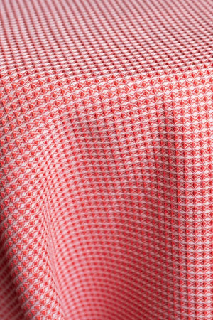 Table linen with vibrant waffle texture in bold coral brings energy and modern charm to contemporary event tables.