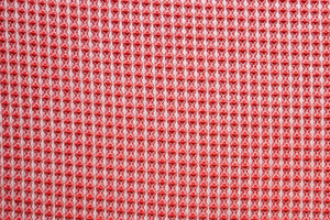 Table linen with vibrant waffle texture in bold coral brings energy and modern charm to contemporary event tables.