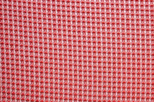 Table linen with vibrant waffle texture in bold coral brings energy and modern charm to contemporary event tables.