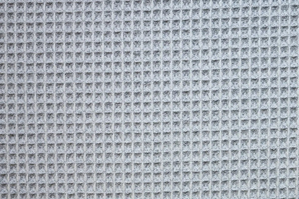Table linen with gentle waffle texture in soft grey adds modern elegance and subtle charm to minimalist event tables.