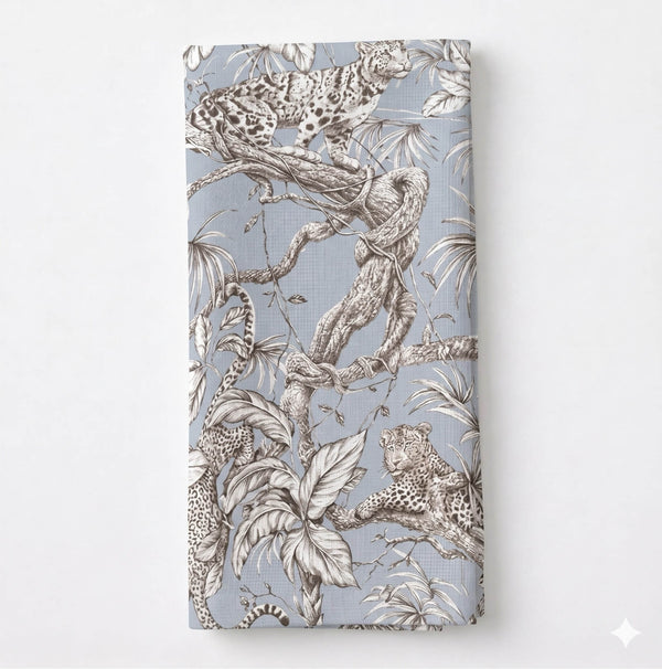 A folded Leonard Dove Linen in grey-blue, showcasing detailed black-and-white leopard and jungle motifs on a light blue background.
