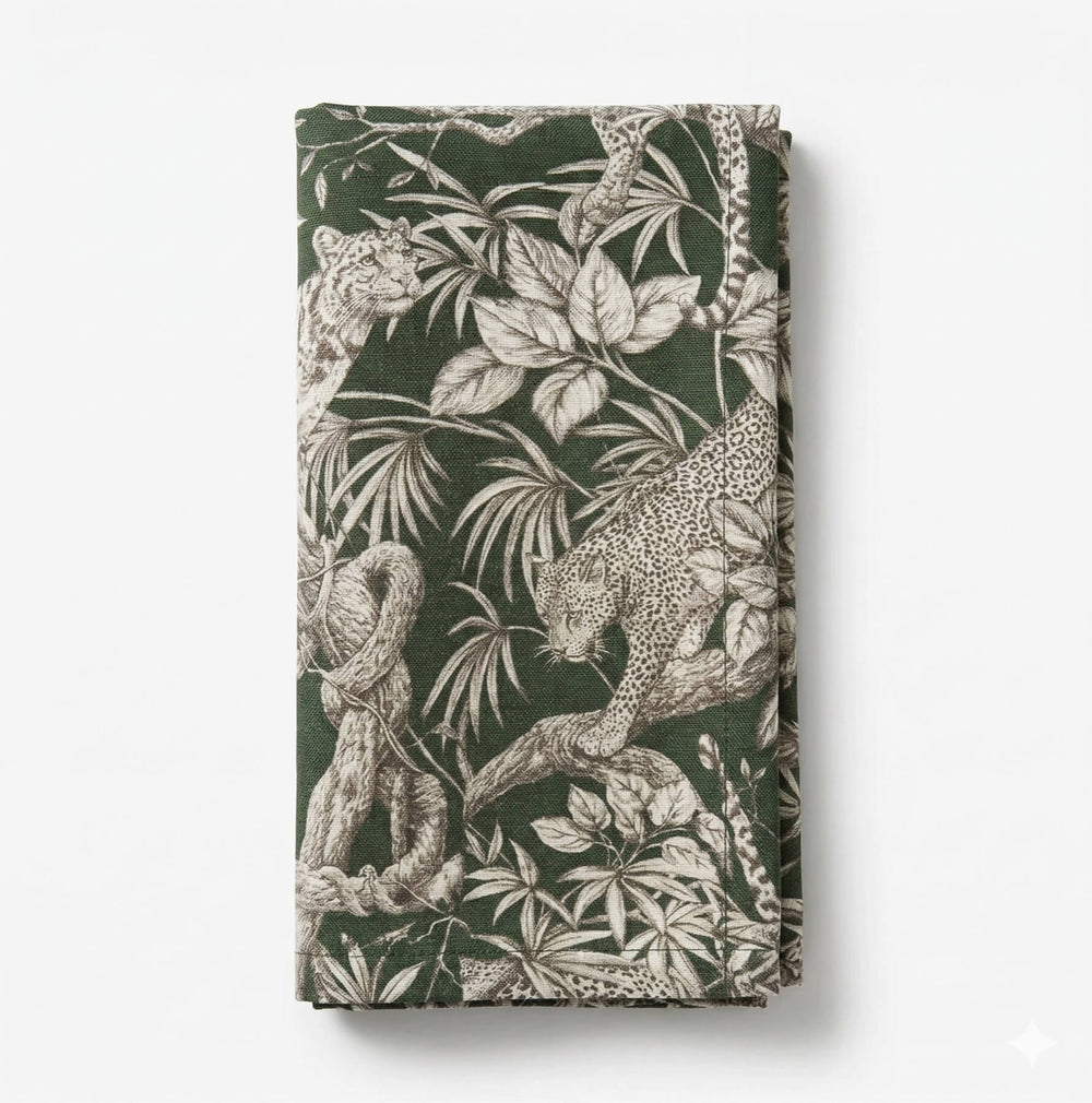 A close-up of the Leonard Olive Linen Sample displays a detailed white jungle pattern with striking leopard motifs, leaves, and tree branches on olive linen.