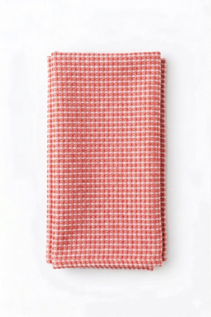 The Waffle Coral Linen kitchen towel in red and white adds modern style to your table, perfect for daily use or elevating event decor.