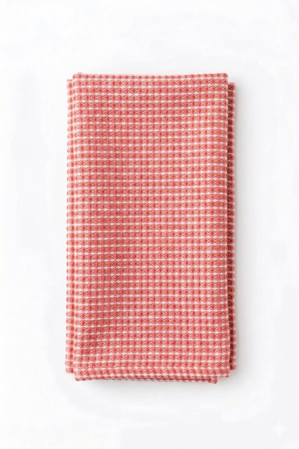 The Waffle Coral Linen kitchen towel in red and white adds modern style to your table, perfect for daily use or elevating event decor.