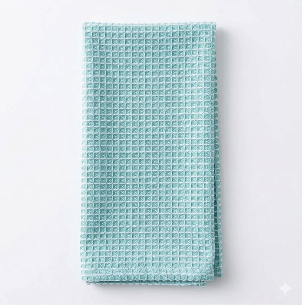 A neatly folded Waffle Duck Egg Linen towel with a textured waffle pattern is displayed on a plain white background.